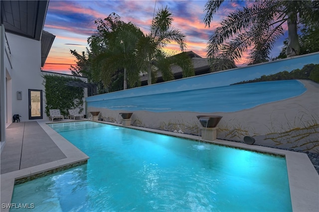 view of pool at dusk