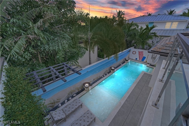 view of pool at dusk