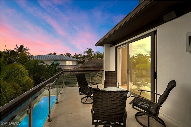 patio terrace at dusk featuring a balcony