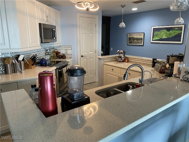 kitchen with sink, backsplash, electric range, pendant lighting, and white cabinetry