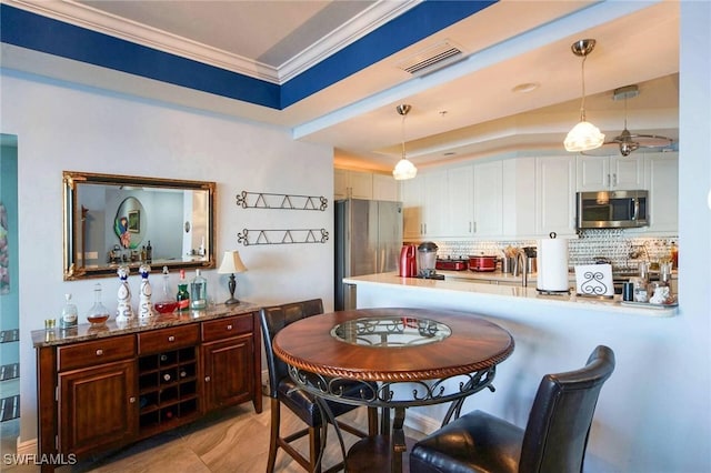 dining area featuring ornamental molding and a raised ceiling