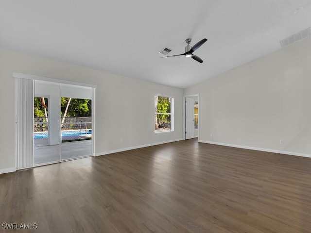 empty room featuring dark hardwood / wood-style floors, vaulted ceiling, and ceiling fan