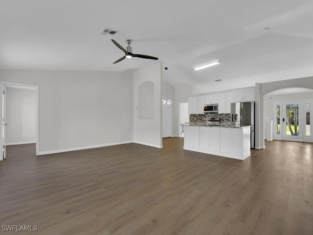 unfurnished living room featuring dark wood-type flooring, vaulted ceiling, and ceiling fan