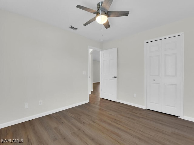 unfurnished bedroom with a closet, dark hardwood / wood-style floors, and ceiling fan