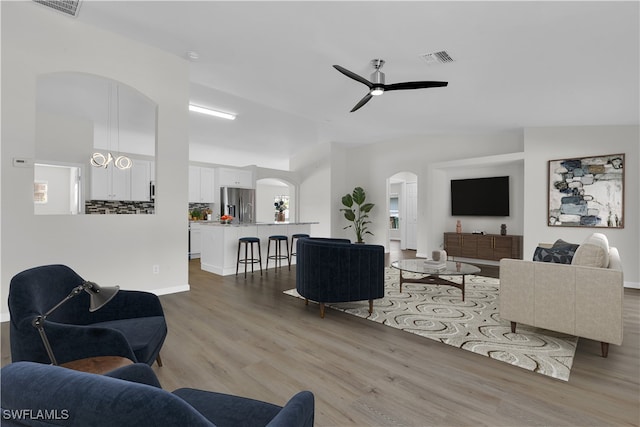 living room with lofted ceiling, light hardwood / wood-style floors, and ceiling fan