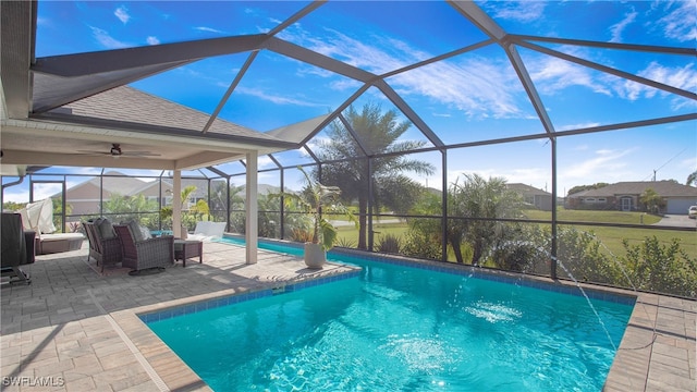 view of pool featuring glass enclosure, pool water feature, outdoor lounge area, and a patio