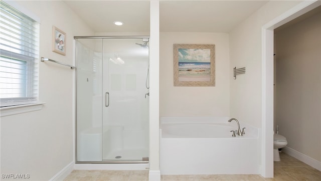 bathroom with tile patterned flooring, shower with separate bathtub, toilet, and a wealth of natural light