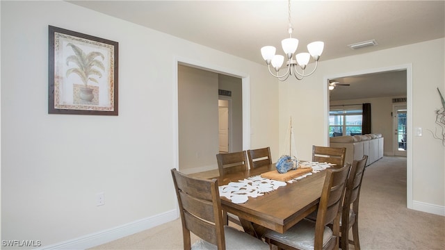 dining area with ceiling fan with notable chandelier and light colored carpet