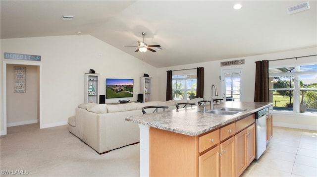 kitchen with vaulted ceiling, ceiling fan, a kitchen island with sink, sink, and dishwasher