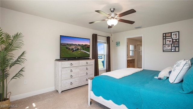 bedroom featuring connected bathroom, light colored carpet, and ceiling fan