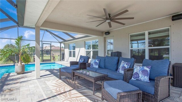 view of patio with an outdoor hangout area, glass enclosure, and ceiling fan