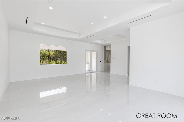 unfurnished room featuring a raised ceiling and french doors