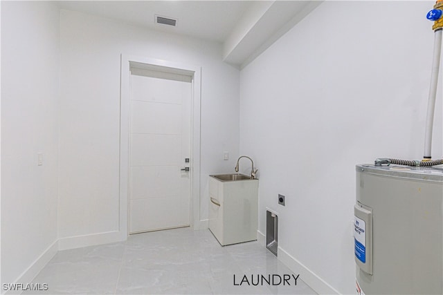 clothes washing area featuring electric water heater, electric dryer hookup, and sink