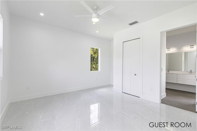 unfurnished bedroom featuring ceiling fan, connected bathroom, and a closet