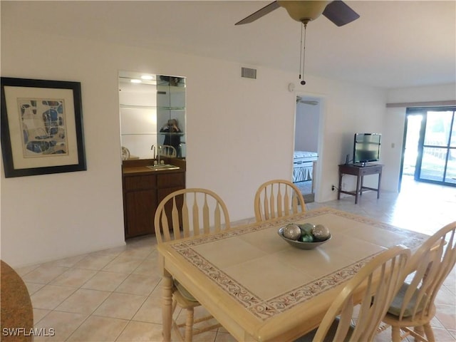 tiled dining space featuring sink and ceiling fan