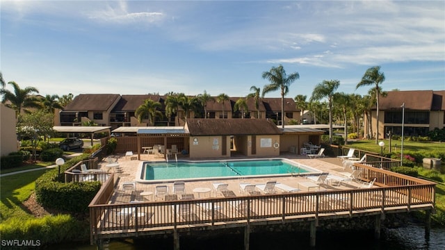 view of pool featuring a deck with water view and a patio area