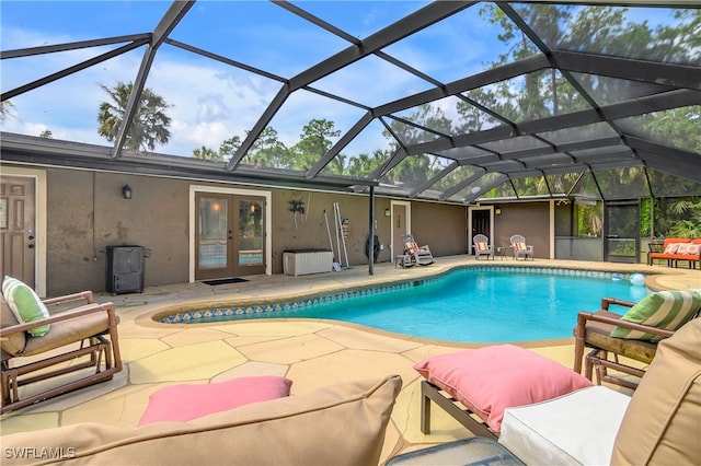 view of swimming pool with a lanai, french doors, and a patio