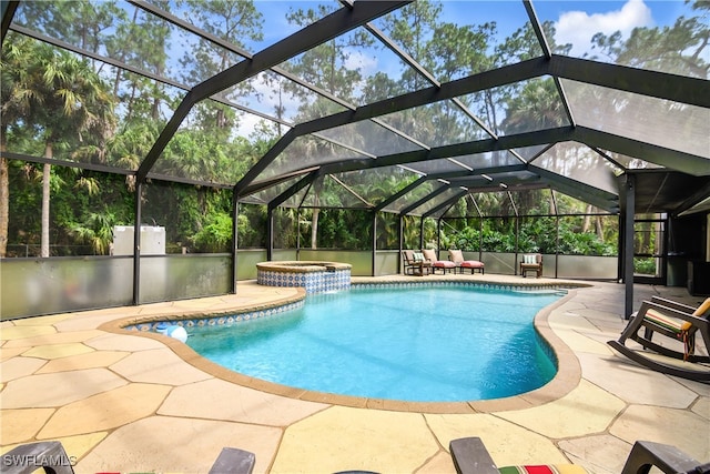 view of swimming pool featuring a patio, glass enclosure, and an in ground hot tub