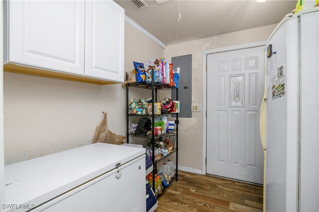 laundry room featuring cabinets, electric panel, dark hardwood / wood-style floors, and crown molding