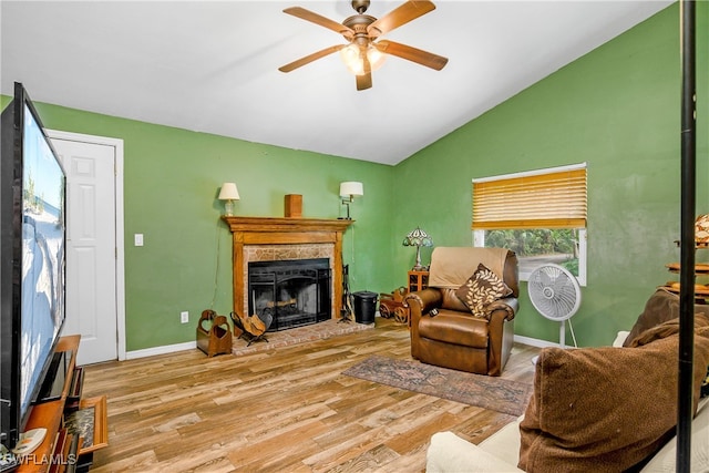 living room with ceiling fan, light wood-type flooring, and vaulted ceiling