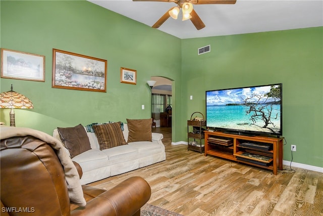 living room with ceiling fan, light hardwood / wood-style flooring, and high vaulted ceiling