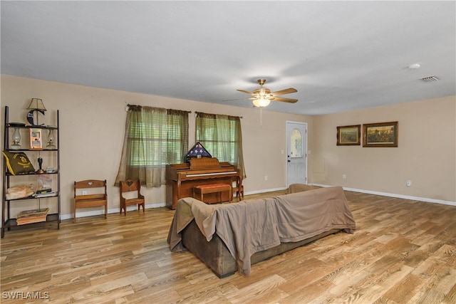 living room with ceiling fan and light hardwood / wood-style flooring