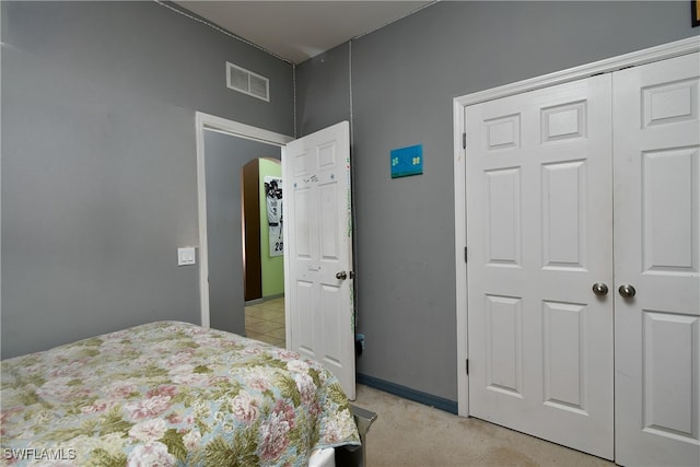 bedroom with light colored carpet and a closet