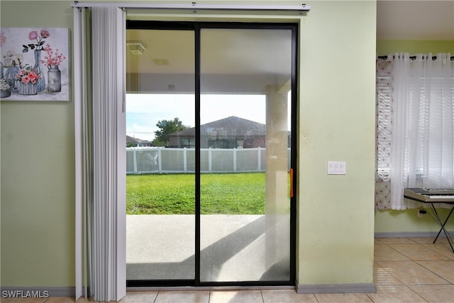 doorway to outside with light tile patterned floors