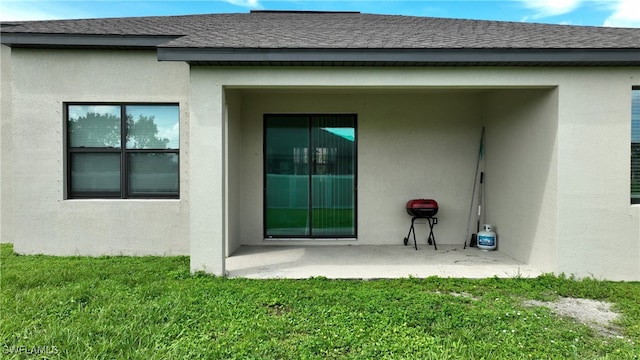 back of house with a lawn and a patio