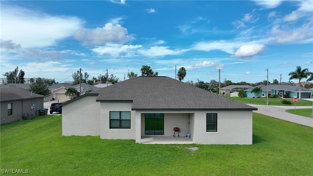 rear view of house with a lawn and central AC unit