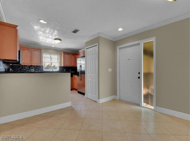 kitchen with backsplash, kitchen peninsula, stainless steel fridge, light tile patterned floors, and ornamental molding