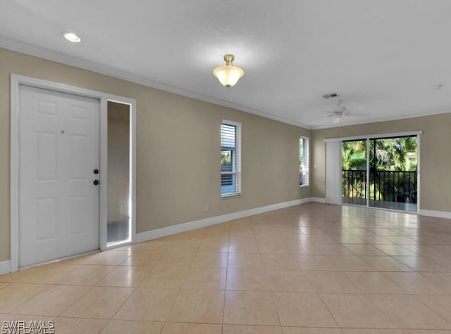 foyer with a wealth of natural light, light tile patterned floors, ornamental molding, and ceiling fan