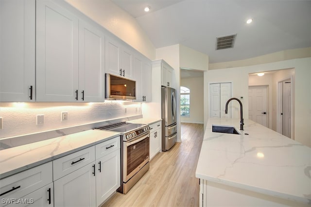 kitchen featuring light stone countertops, sink, stainless steel appliances, light hardwood / wood-style flooring, and white cabinets