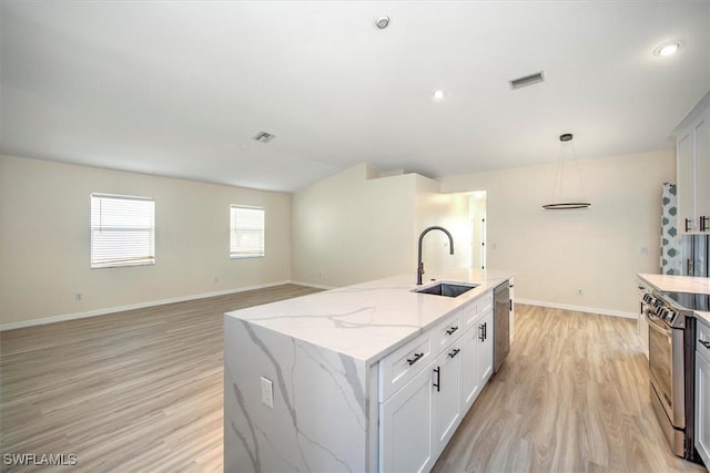 kitchen featuring appliances with stainless steel finishes, a kitchen island with sink, sink, white cabinets, and light hardwood / wood-style floors