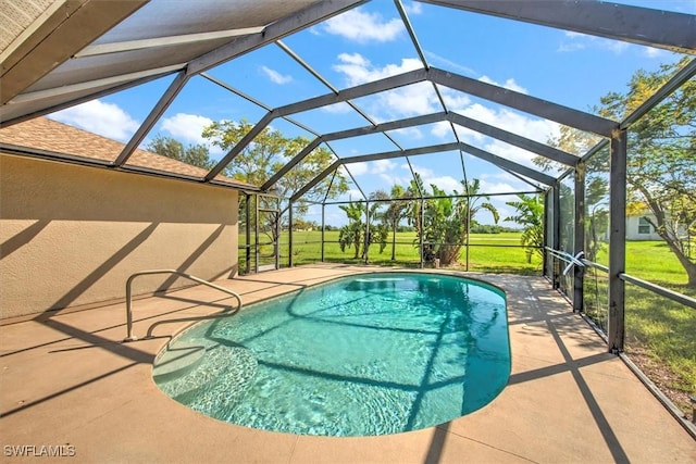 view of pool featuring glass enclosure, a yard, and a patio