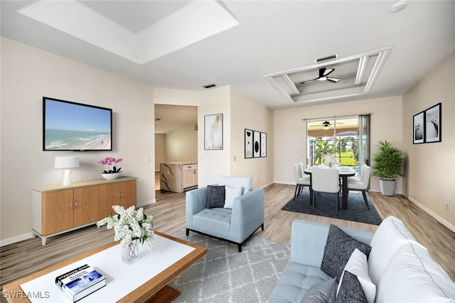 living room with a tray ceiling and hardwood / wood-style flooring