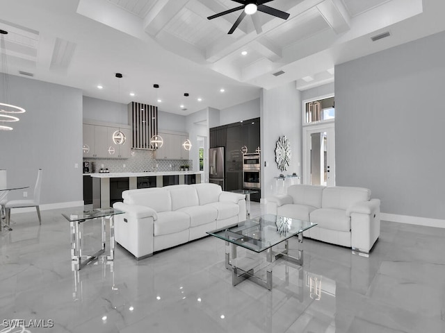 living room with beamed ceiling, a high ceiling, and ceiling fan with notable chandelier