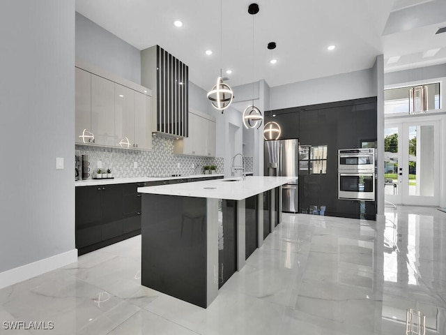 kitchen featuring a spacious island, decorative backsplash, pendant lighting, white cabinetry, and appliances with stainless steel finishes