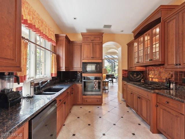 kitchen featuring tasteful backsplash, sink, dark stone counters, and black appliances