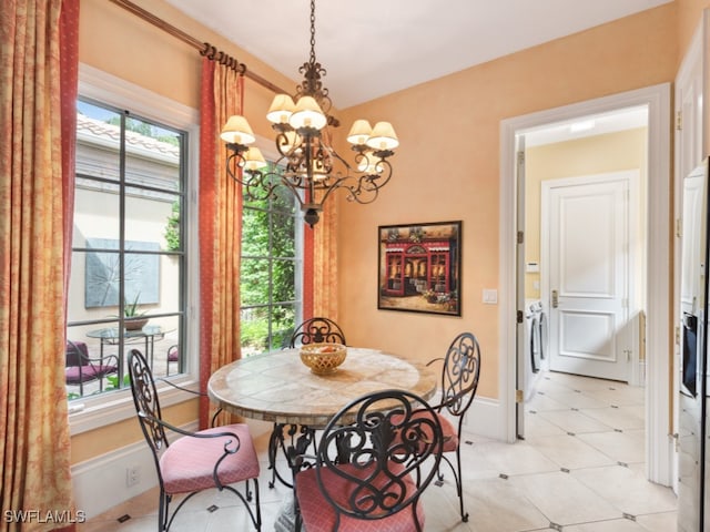 dining area featuring separate washer and dryer and an inviting chandelier