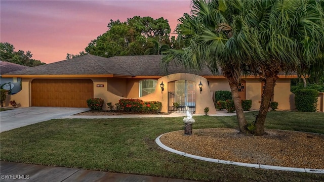 view of front of property featuring a lawn and a garage