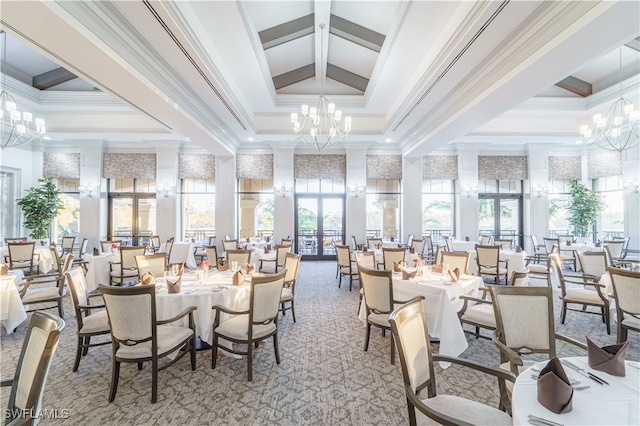 dining room with decorative columns, a high ceiling, a tray ceiling, and a notable chandelier