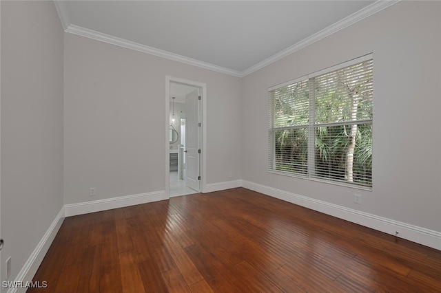 empty room with hardwood / wood-style flooring and crown molding