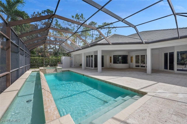 view of pool with an in ground hot tub, glass enclosure, and a patio area