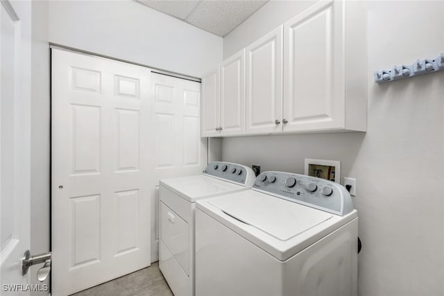 washroom featuring cabinets and washing machine and clothes dryer