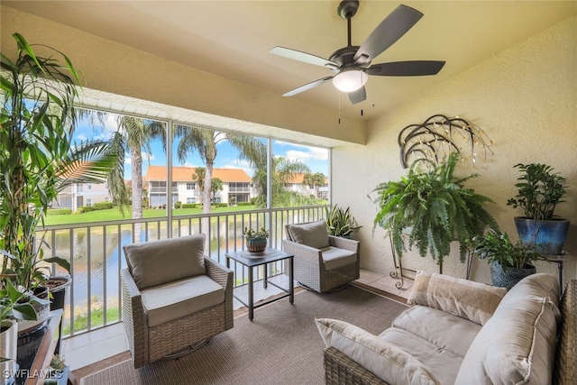 sunroom with a water view and ceiling fan