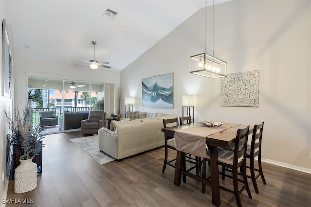 dining space featuring high vaulted ceiling, dark hardwood / wood-style flooring, and ceiling fan with notable chandelier