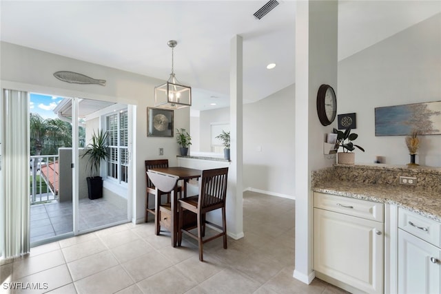 dining space with an inviting chandelier and light tile patterned floors