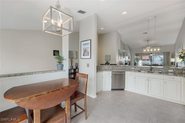 kitchen featuring hanging light fixtures, kitchen peninsula, vaulted ceiling, stainless steel dishwasher, and white cabinetry