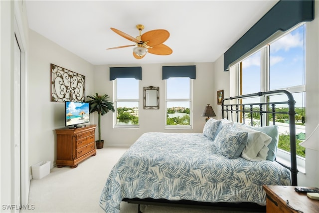 carpeted bedroom with multiple windows, a closet, and ceiling fan